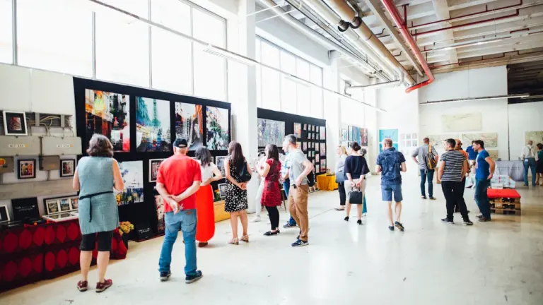 Besucher betrachten moderne Kunstwerke in einer hellen Galerie mit hohen Decken in Deutschland.