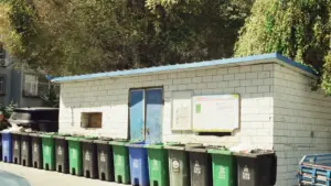 Eine Reihe von Mülltonnen vor einem Gebäude am Recyclinghof für die Müllentsorgung
