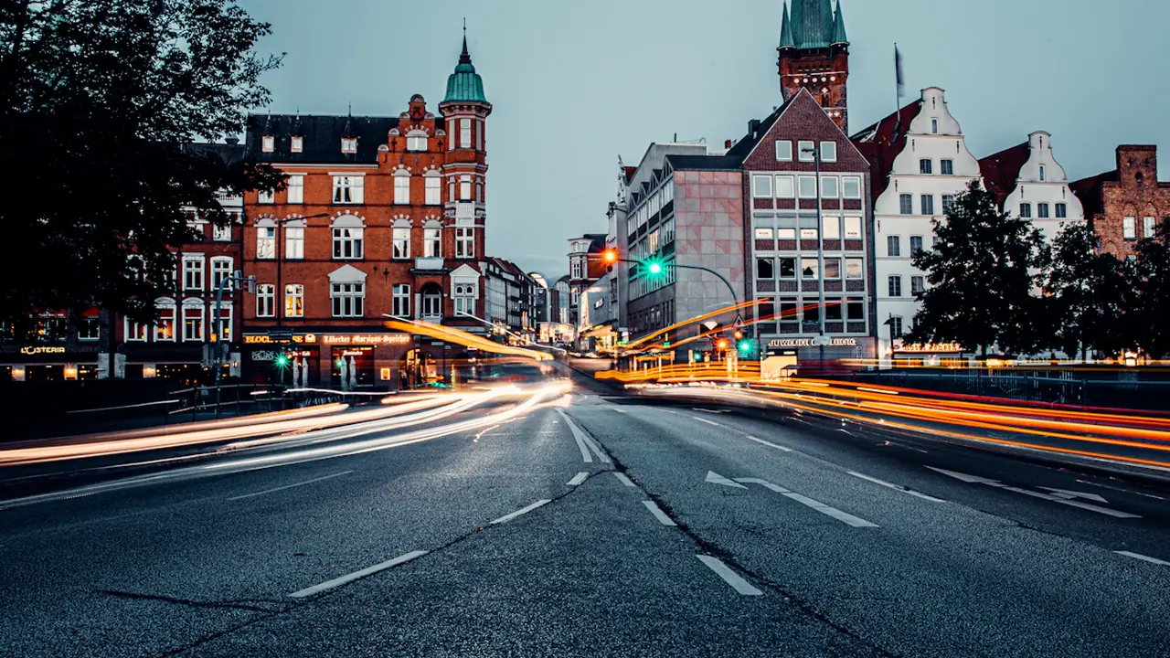 Langzeitbelichtung einer beleuchteten deutschen Innenstadtstraße bei Nacht mit historischen Gebäuden.