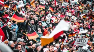 Menschenmenge mit Deutschlandfahnen bei einer öffentlichen Feier zum Tag der Deutschen Einheit.